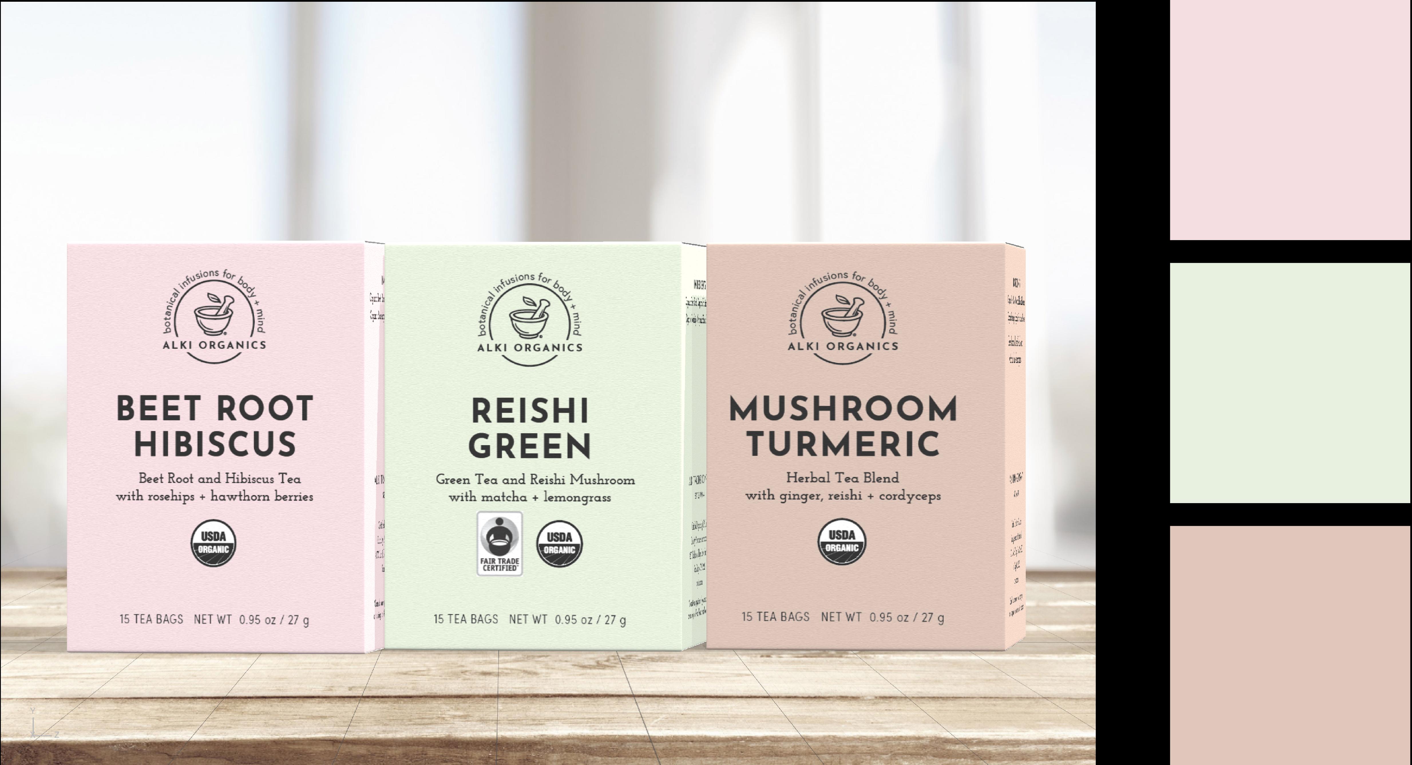 Three boxes of Alki Organics tea, including Beet Root Hibiscus, Reishi Green, and Mushroom Turmeric on a light wood surface.